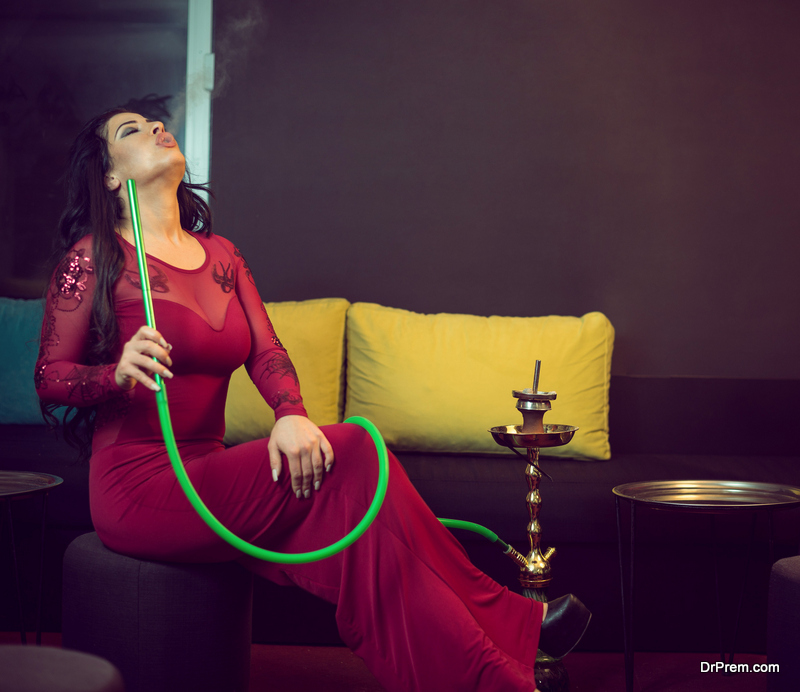 Woman smoking hookah in bar
